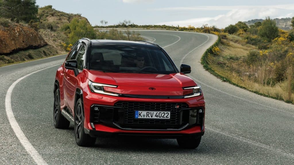 Raudonas Toyota RAV4 hibridas iš šono